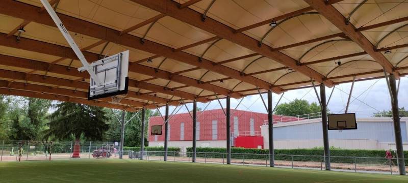 Buts de basket charpente relevable électriquement avec panneau polyester dans préau sportif 