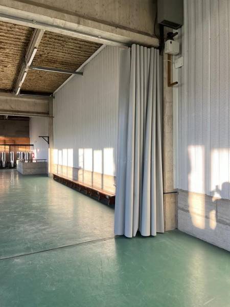 Rideau de séparation en bâche grise en position repliée 