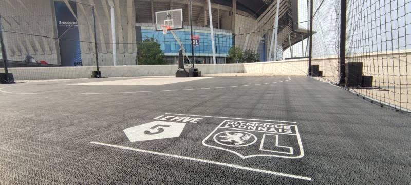 Sol sportif avec logo du club de Lyon et du five OL avec son panier de basket