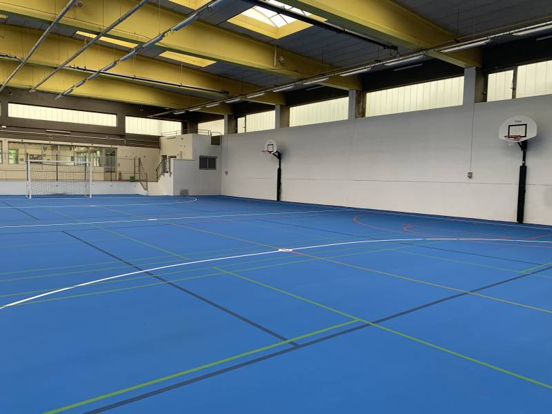 Vue du terrain en large avec les buts de basketball sur les côté